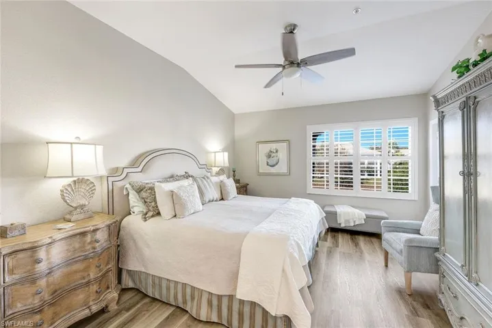 Bedroom with wood finished floors, vaulted ceiling, and a ceiling fan