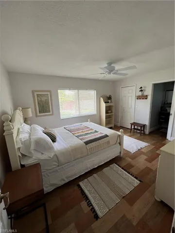 Bedroom featuring wood finished floors, a textured ceiling, and ceiling fan