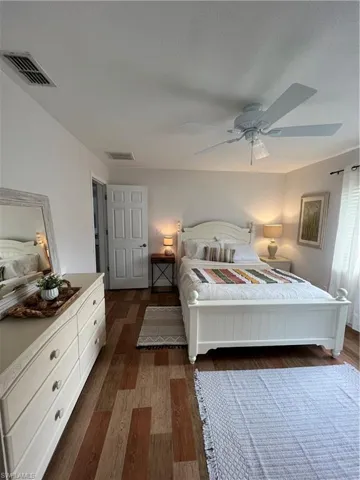 Bedroom featuring dark wood-style floors, a ceiling fan, and a textured ceiling