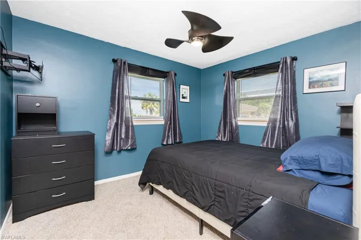 Carpeted bedroom featuring ceiling fan