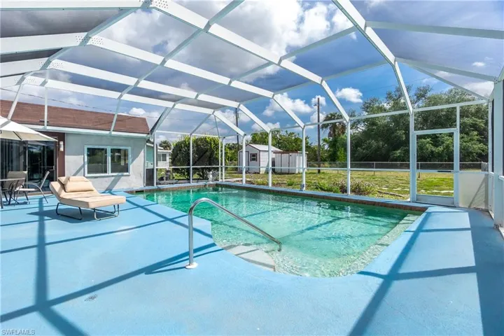 View of pool with a patio area and a lanai