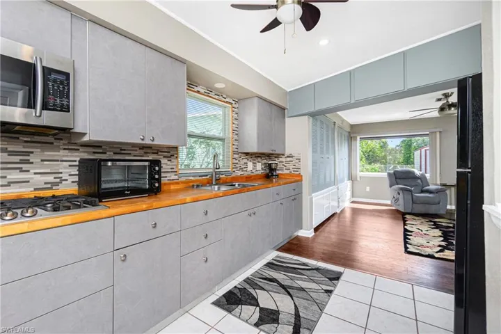 Kitchen featuring wood counters, sink, light wood-type flooring, a healthy amount of sunlight, and stainless steel appliances
