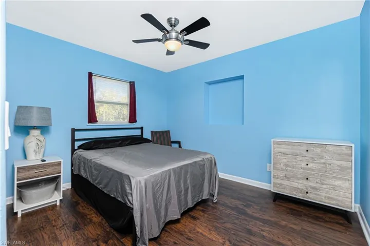 Bedroom with ceiling fan and dark hardwood / wood-style floors
