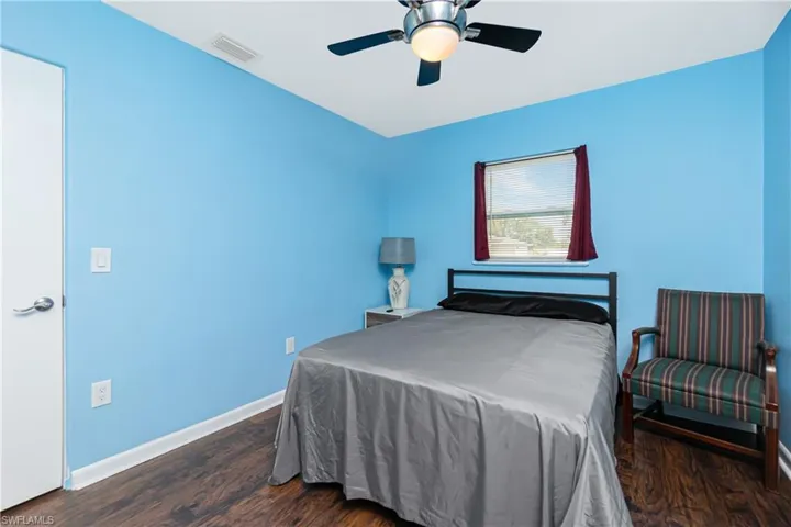 Bedroom with ceiling fan and dark wood-type flooring