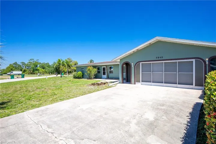 Ranch-style house featuring a garage and a front lawn
