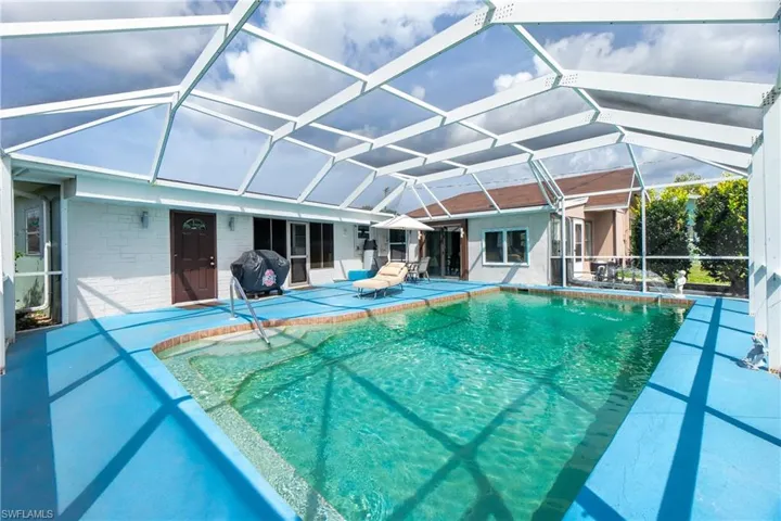 View of pool featuring a grill, a patio area, and a lanai