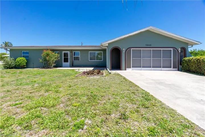 Ranch-style house with a front yard and a garage