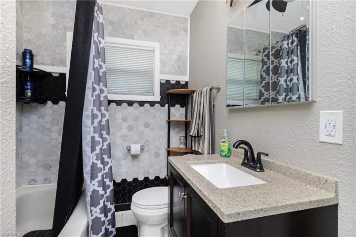 Full bathroom with shower / bath combination with curtain, vanity, and toilet