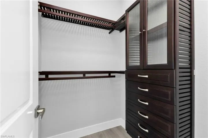 Walk in closet with light wood finished floors