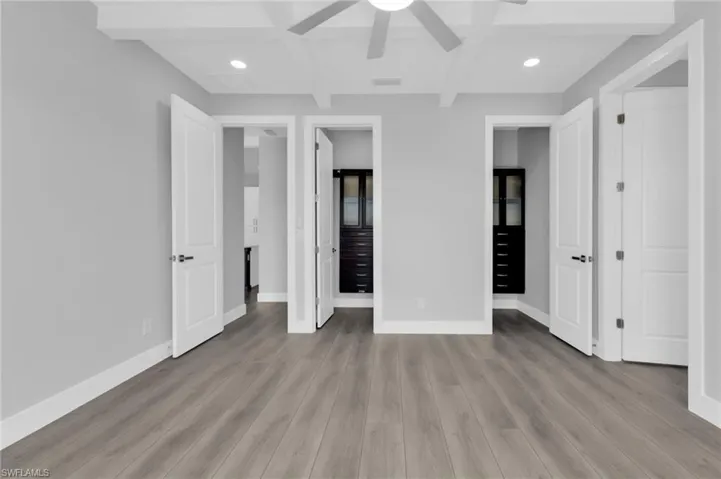 Unfurnished bedroom with beamed ceiling, coffered ceiling, recessed lighting, light wood-type flooring, and ceiling fan