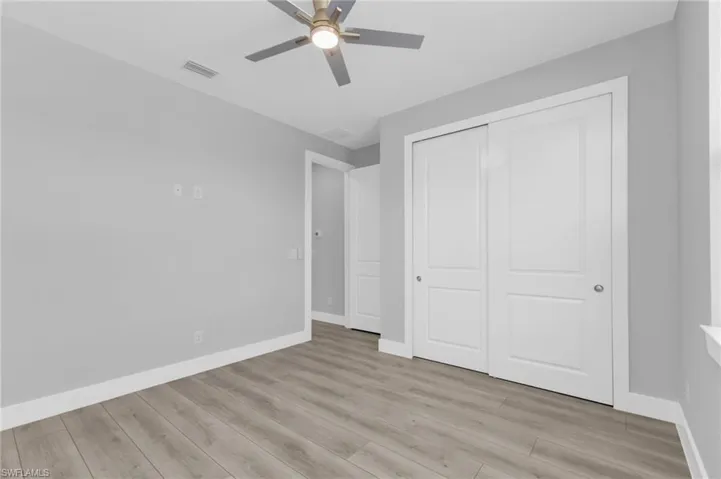 Unfurnished bedroom with light wood-style flooring, a ceiling fan, and a closet