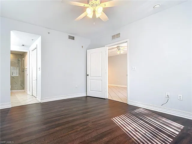 Spare room featuring visible vents, baseboards, wood finished floors, and a ceiling fan