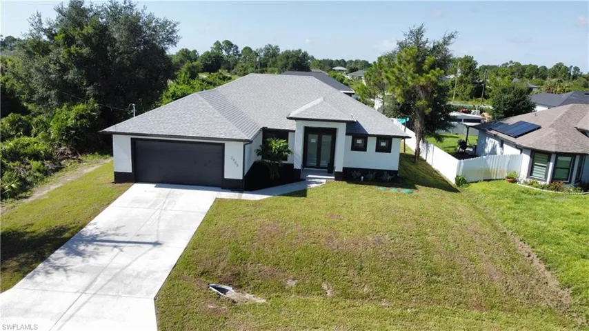 View of front of home with a garage and a front lawn