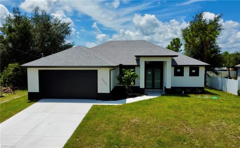 View of front of home with a garage and a front yard