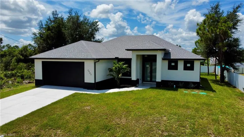 View of front of house with a garage and a front yard