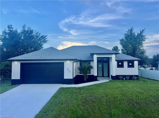 View of front of home with a garage and a front yard