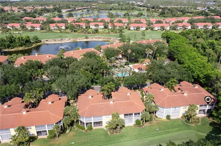 Aerial view of property's location featuring a large body of water, nearby suburban area, and a golf course