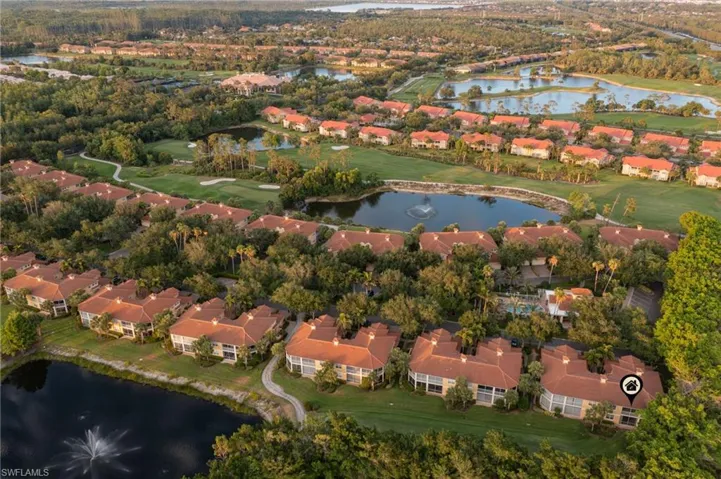Aerial view of property and surrounding area with nearby suburban area, a nearby body of water, and a golf course