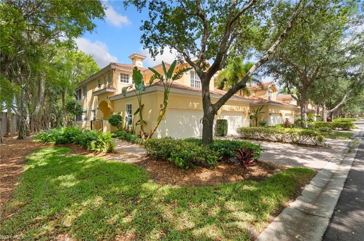 View of home's exterior featuring an attached garage, stucco siding, a chimney, driveway, and a tile roof