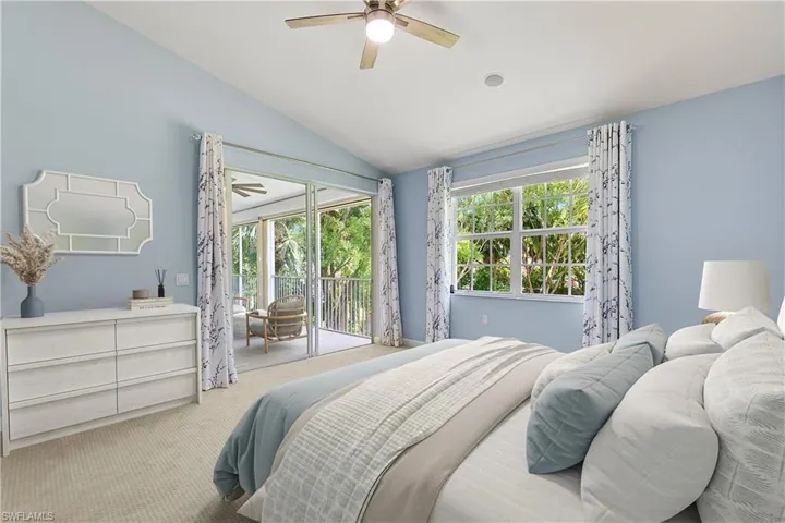 Virtually Staged | Carpeted bedroom featuring access to exterior, lofted ceiling, and a ceiling fan