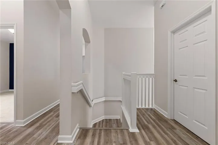 Staircase with wood finished floors and baseboards