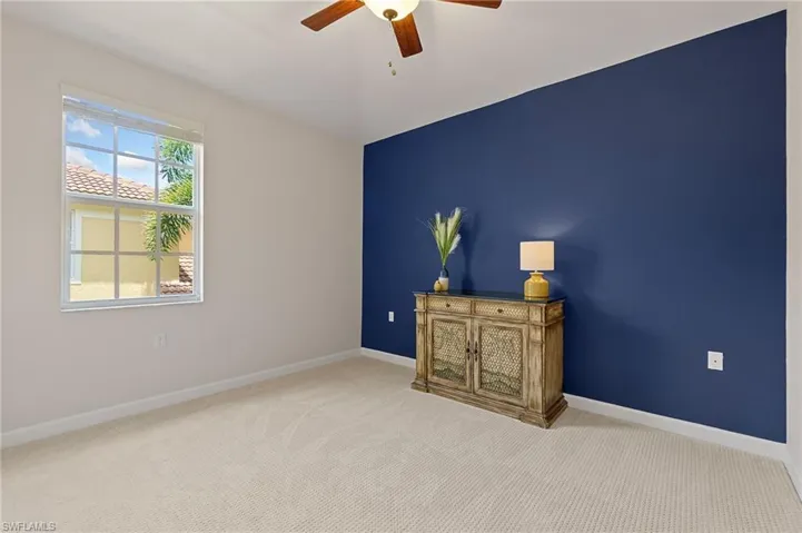 Spare room with a ceiling fan, carpet, and baseboards