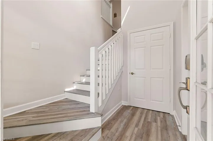 Staircase with wood finished floors and baseboards