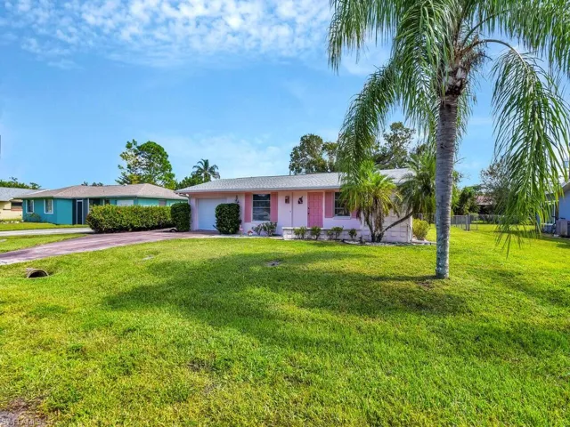 Ranch-style house featuring a front lawn and a garage