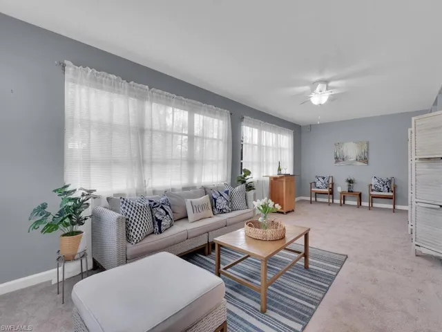 Carpeted living room with ceiling fan