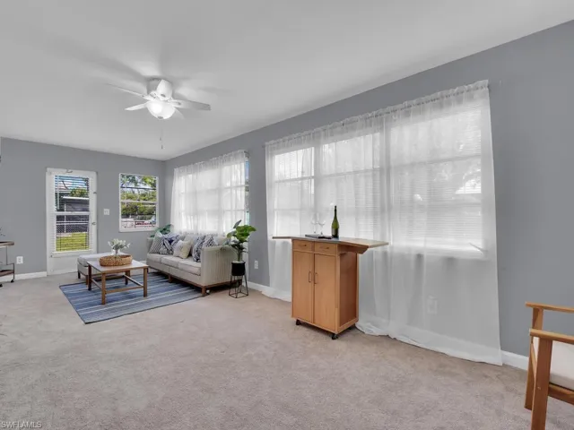 Carpeted living room featuring ceiling fan