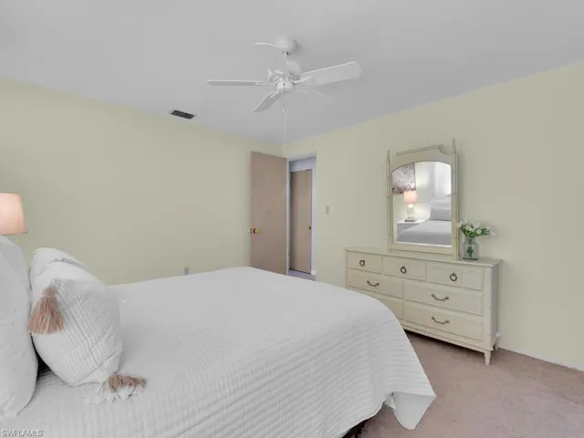 Bedroom with light colored carpet and ceiling fan