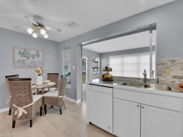 Kitchen featuring white dishwasher, sink, white cabinets, and light hardwood / wood-style floors