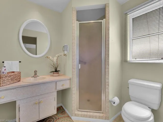 Bathroom featuring vanity, toilet, and an enclosed shower
