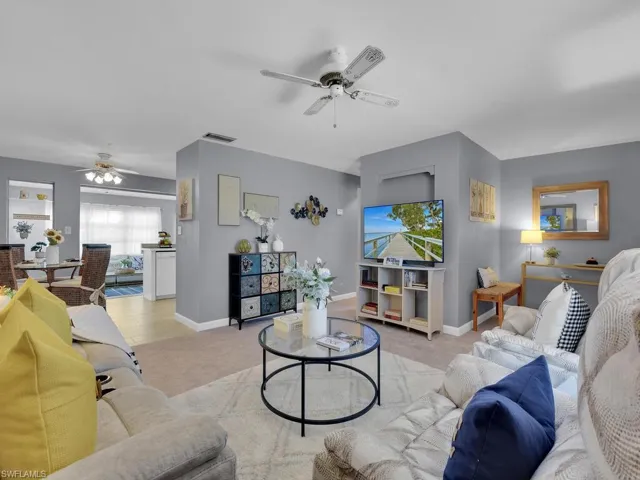 Living room featuring light colored carpet and ceiling fan