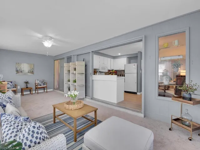 Living room with light colored carpet and ceiling fan