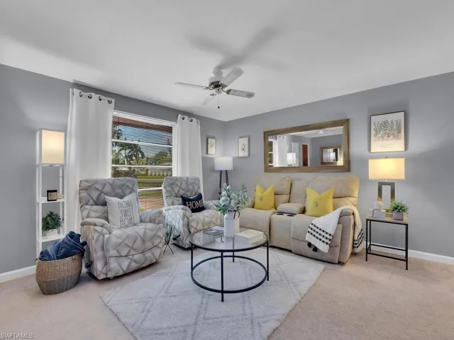 Living room with light colored carpet and ceiling fan