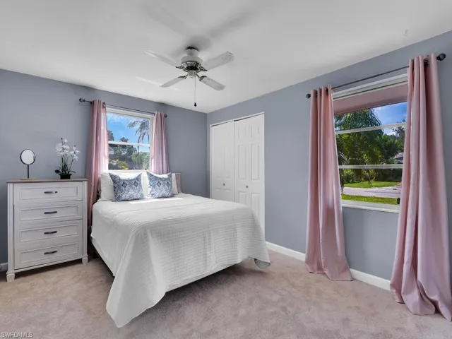 Carpeted bedroom featuring a closet and ceiling fan