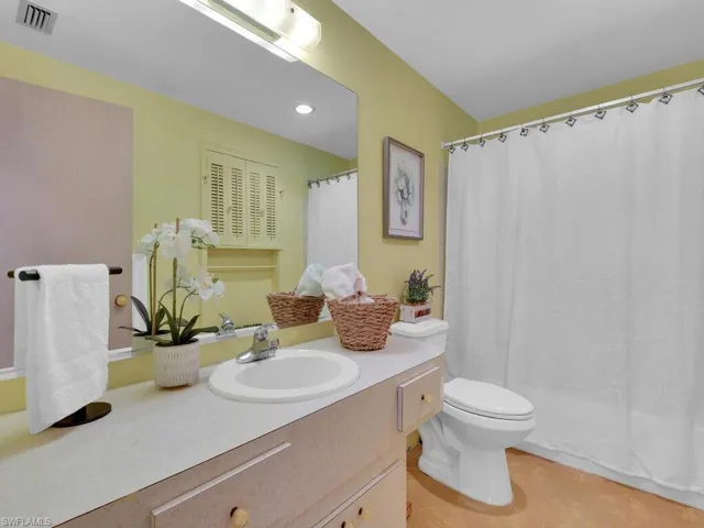 Bathroom featuring vanity, toilet, and a shower with shower curtain
