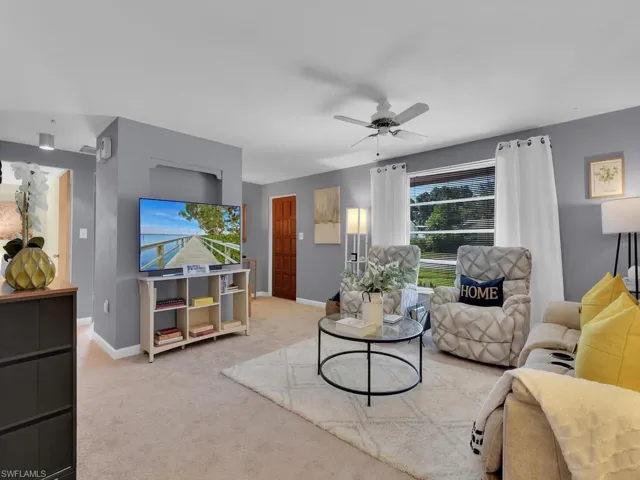 Living room featuring ceiling fan and light colored carpet