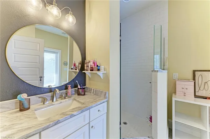 Full bath with a stall shower, vanity, and a chandelier