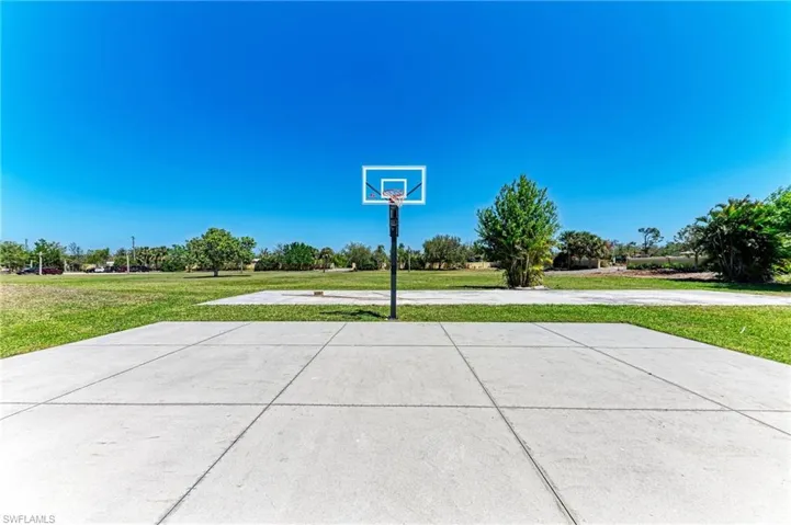 View of basketball court with community basketball court and a yard