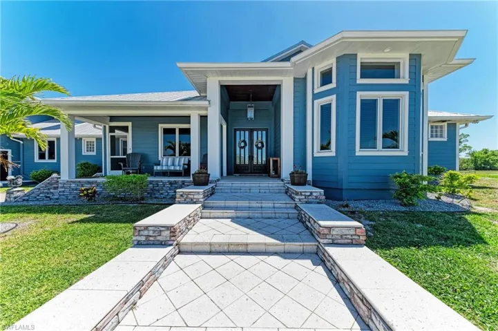 View of front of home featuring french doors, a porch, and a front lawn