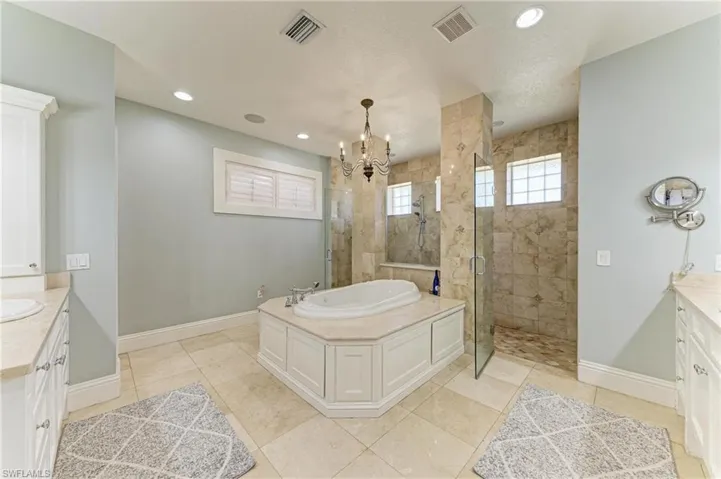 Bathroom featuring vanity, a shower stall, baseboards, and visible vents