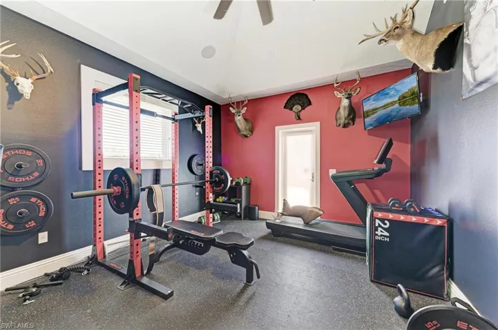 Workout room with baseboards and ceiling fan