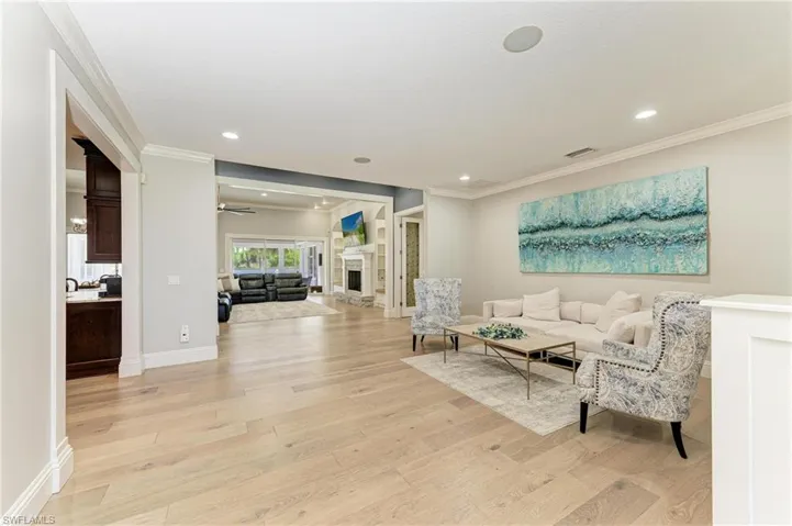 Living room featuring crown molding, baseboards, and light wood-type flooring