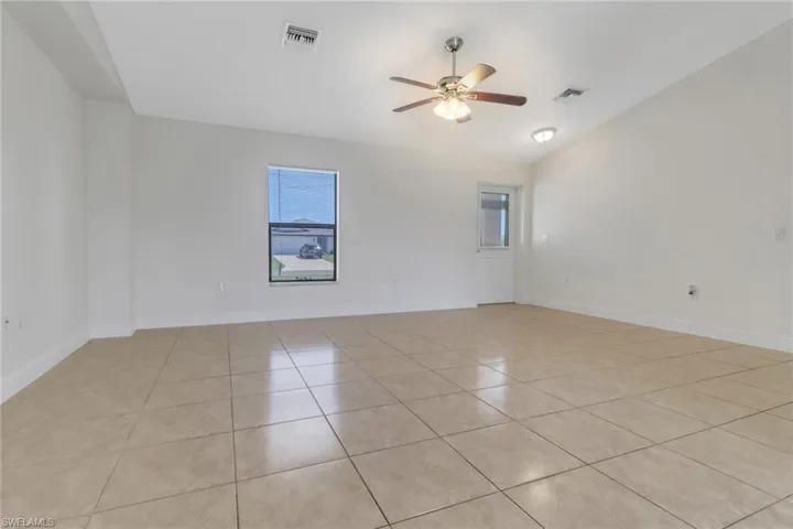 Empty room featuring light tile patterned floors, visible vents, and a ceiling fan
