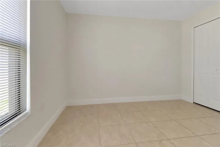 Unfurnished bedroom featuring light tile patterned floors and baseboards