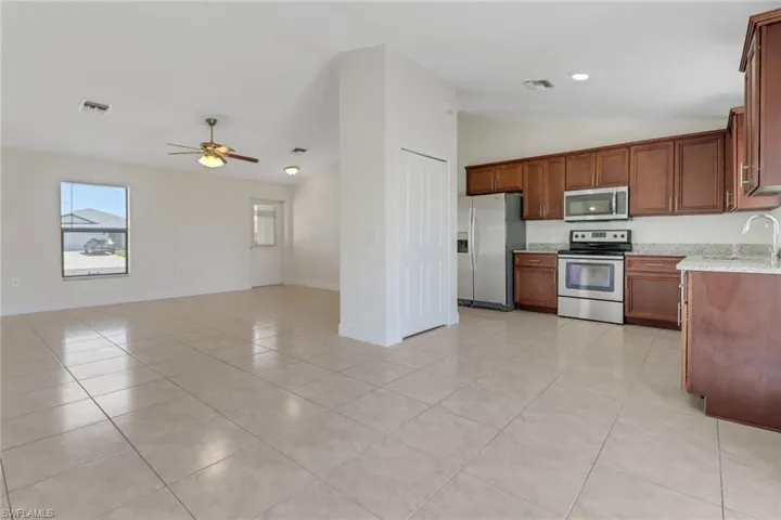 Kitchen with visible vents, ceiling fan, vaulted ceiling, and appliances with stainless steel finishes