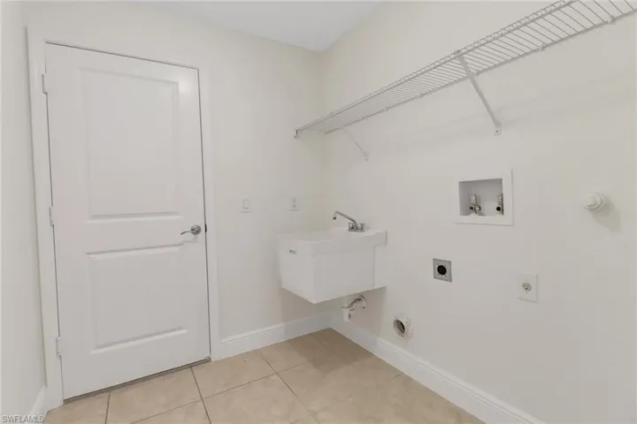 Laundry room with baseboards, electric dryer hookup, light tile patterned flooring, laundry area, and hookup for a washing machine