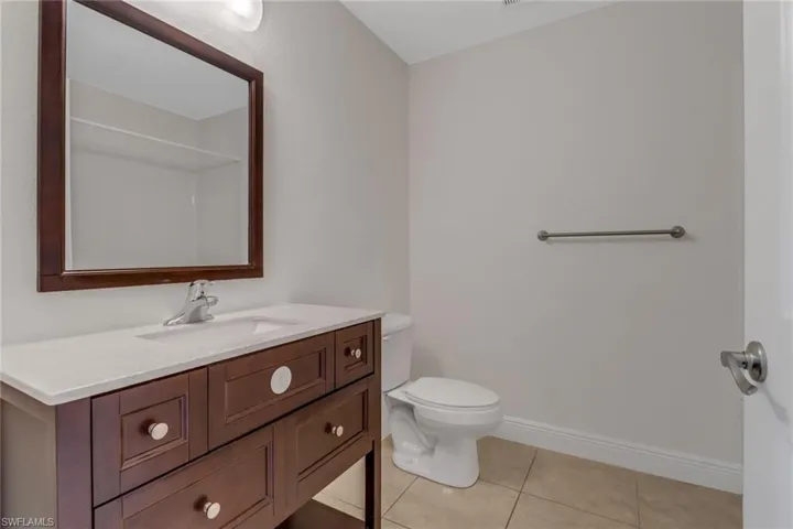 Bathroom featuring tile patterned floors, toilet, vanity, and baseboards